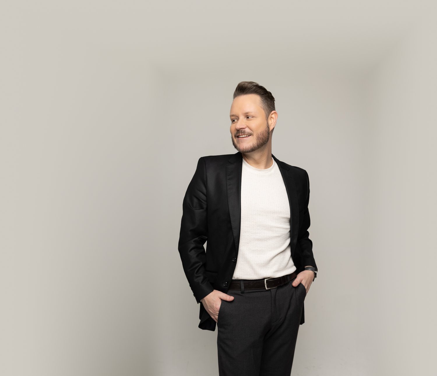 Dr. Marcelo Carvalho de blazer preto e camiseta clara, sorrindo, em fundo claro